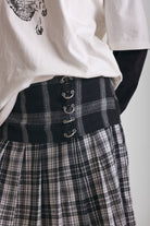 Black and white mixed check midi skirt with silver piercing hardware, worn by model
