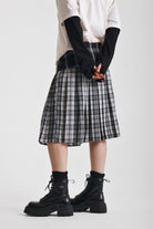 Black and white mixed check midi skirt with silver piercing hardware, worn by model