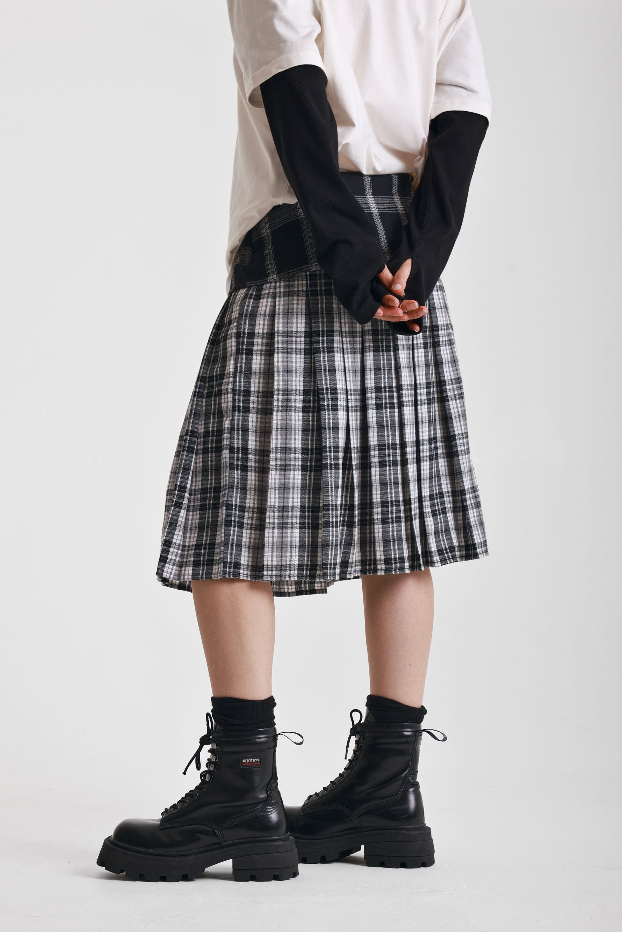 Black and white mixed check midi skirt with silver piercing hardware, worn by model