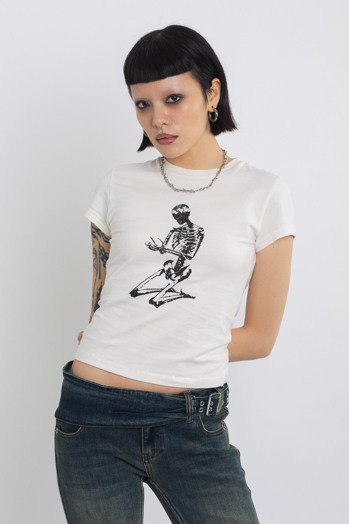 Off white baby t-shirt with praying skeleton graphic print, worn by model