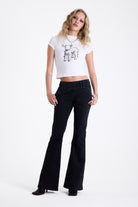 Washed black seam detail flare jeans with studs at waistband and back zip, worn by model. 