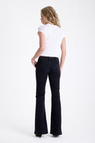 Washed black seam detail flare jeans with studs at waistband and back zip, worn by model. 
