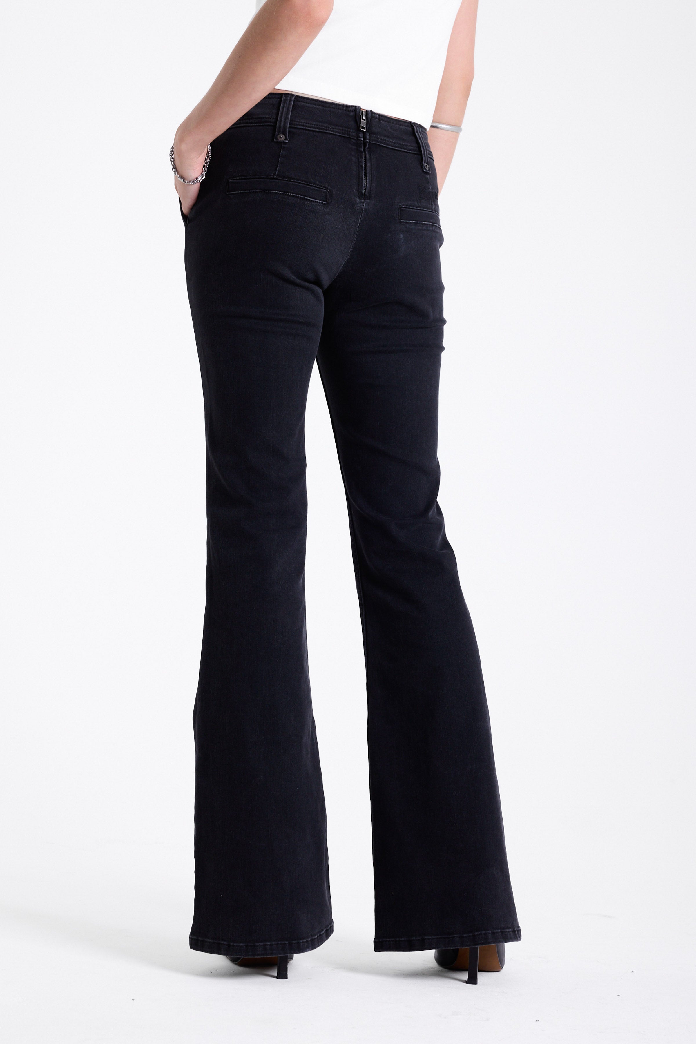 Washed black seam detail flare jeans with studs at waistband and back zip, worn by model. 