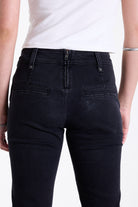 Washed black seam detail flare jeans with studs at waistband and back zip, worn by model. 