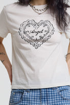 Close up of vintage angel graphic print on white shrunken baby tee, worn by a model