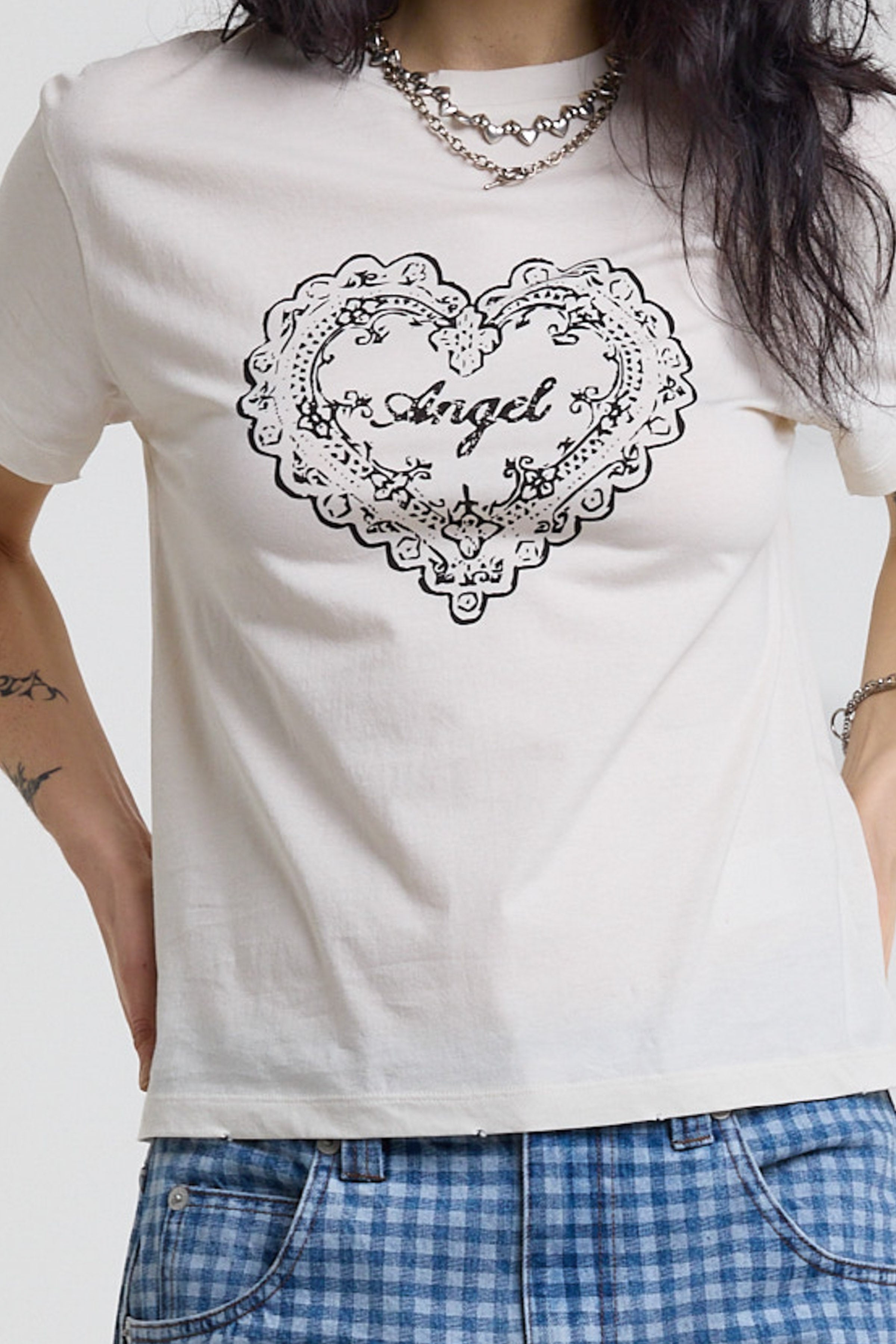 Close up of vintage angel graphic print on white shrunken baby tee, worn by a model