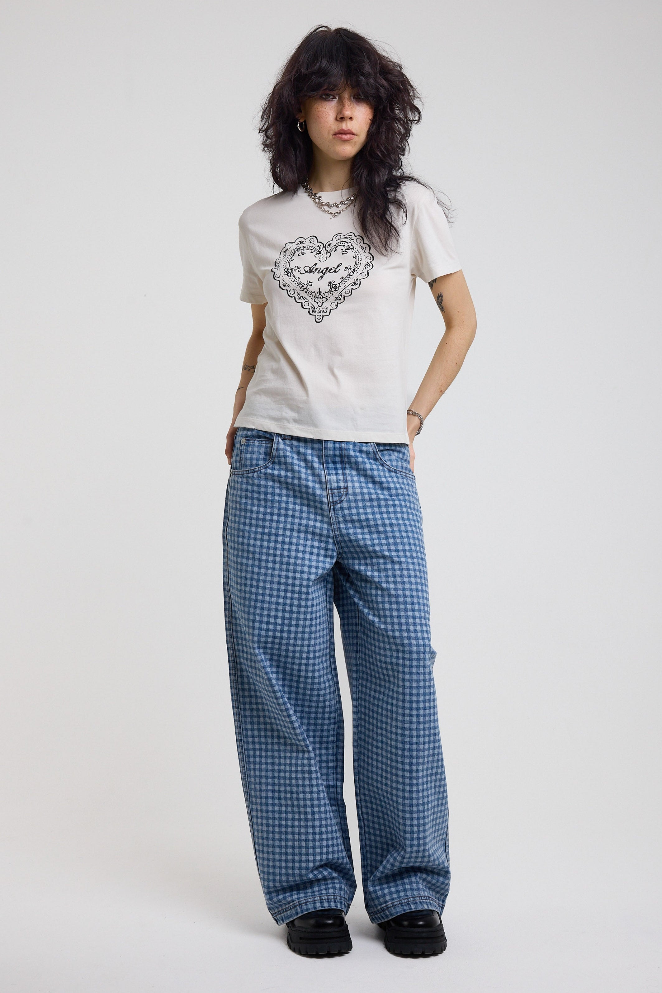 White shrunken baby t-shirt with vintage angel graphic print, worn by a model