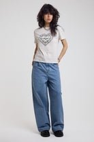 White shrunken baby t-shirt with vintage angel graphic print, worn by a model