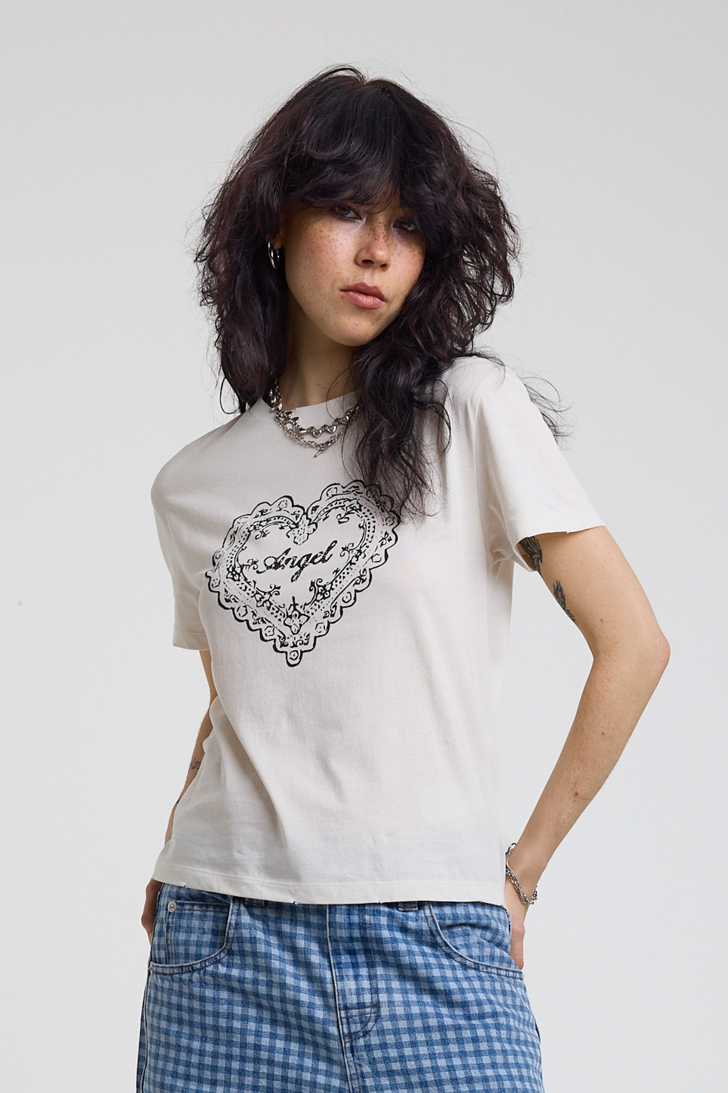 White shrunken baby t-shirt with vintage angel graphic print, worn by a model