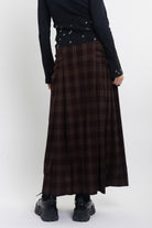 Burgundy check kilt style maxi skirt with silver buckles at the side, worn by model