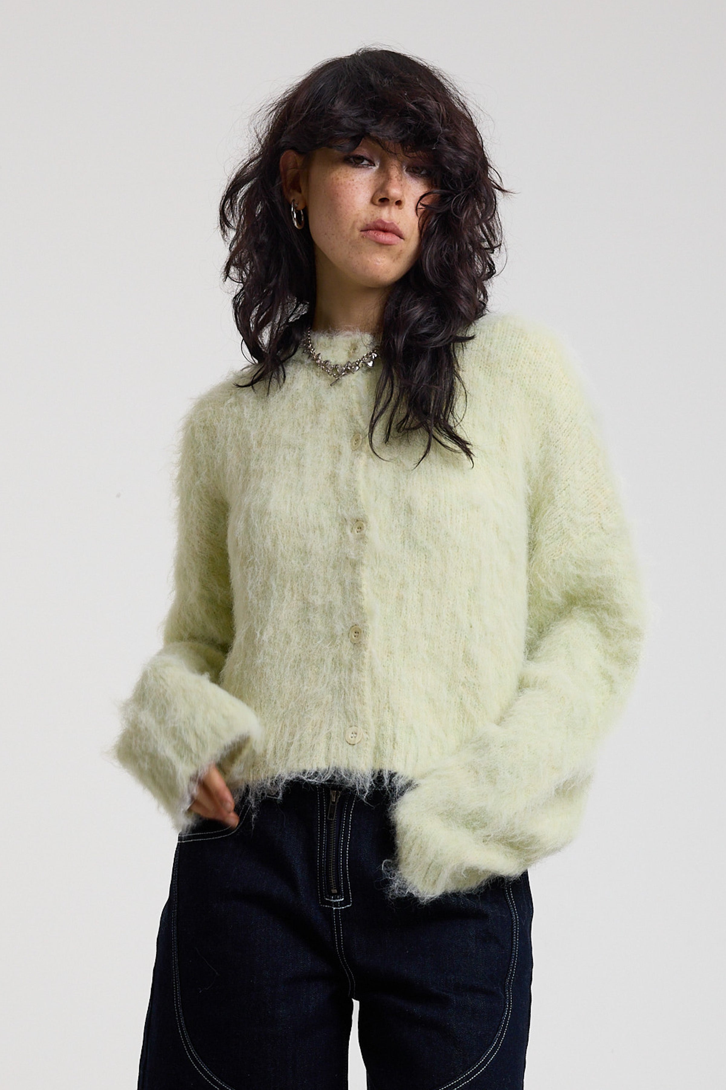 Pale green fuzzy knit cardigan with gothic Baby slogan on back, worn by model