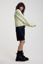 Pale green fuzzy knit cardigan with gothic Baby slogan on back, worn by model