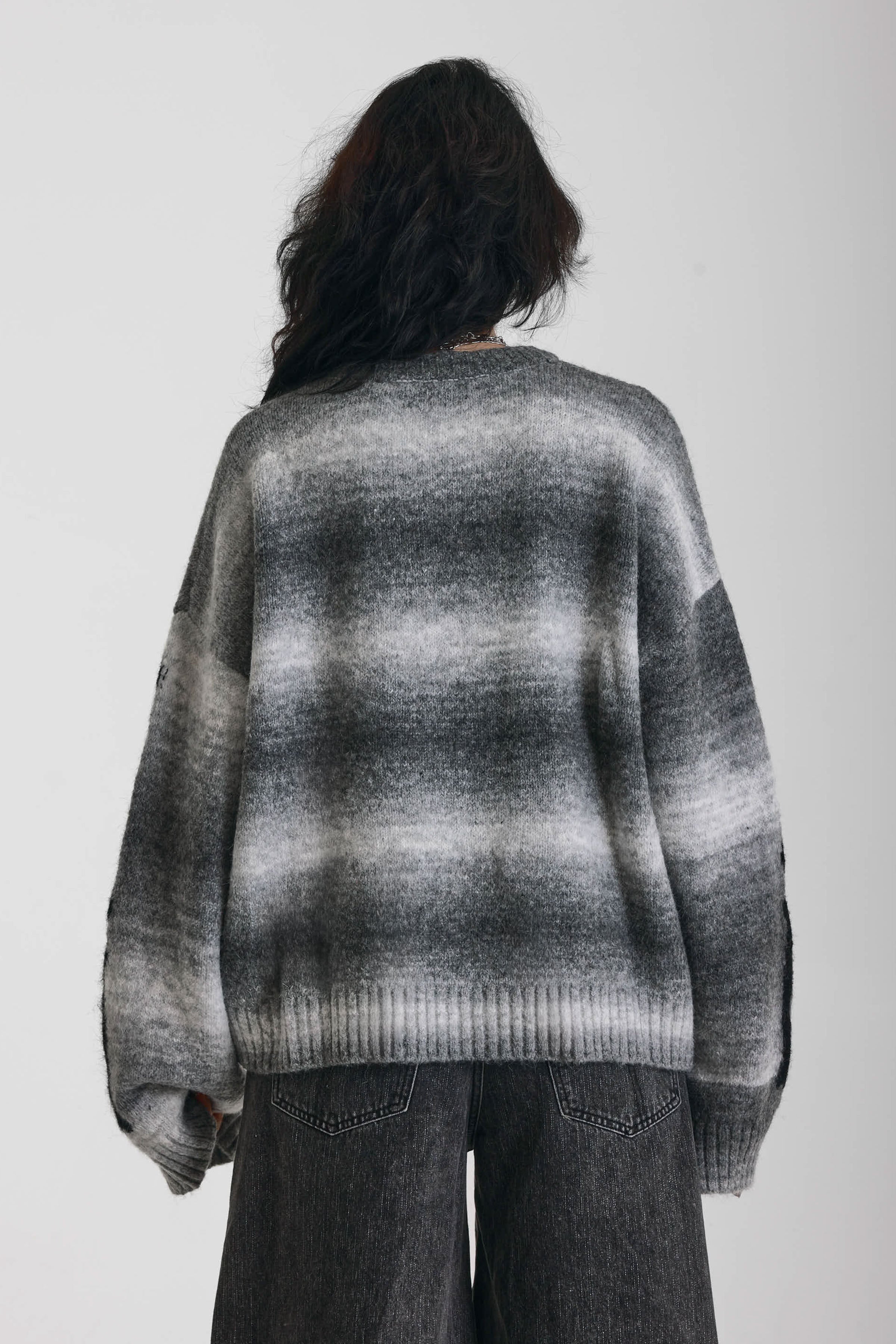 Grey spacedye stripe oversized knit jumper with skeleton ribcage graphic, worn by model