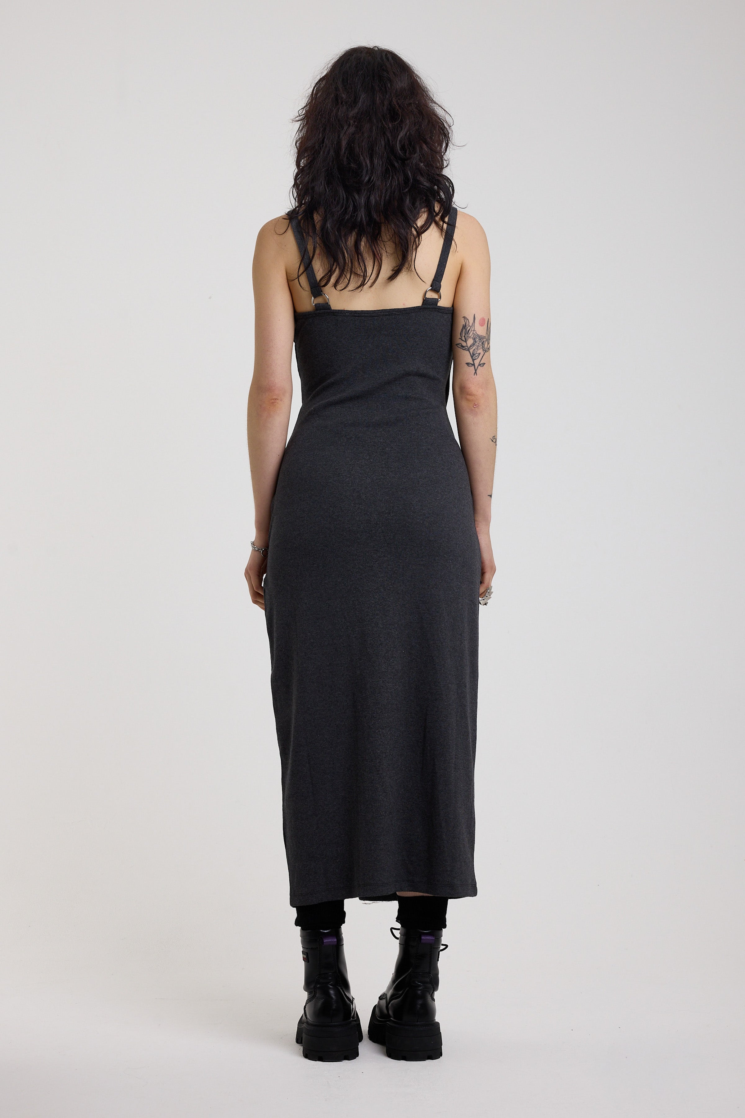 Back of charcoal plunging wrap dress with silver hardware clasps and D-ring strap detail, worn by model