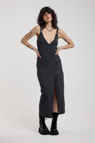 Charcoal plunging wrap dress with silver hardware clasps and D-ring strap detail, worn by model