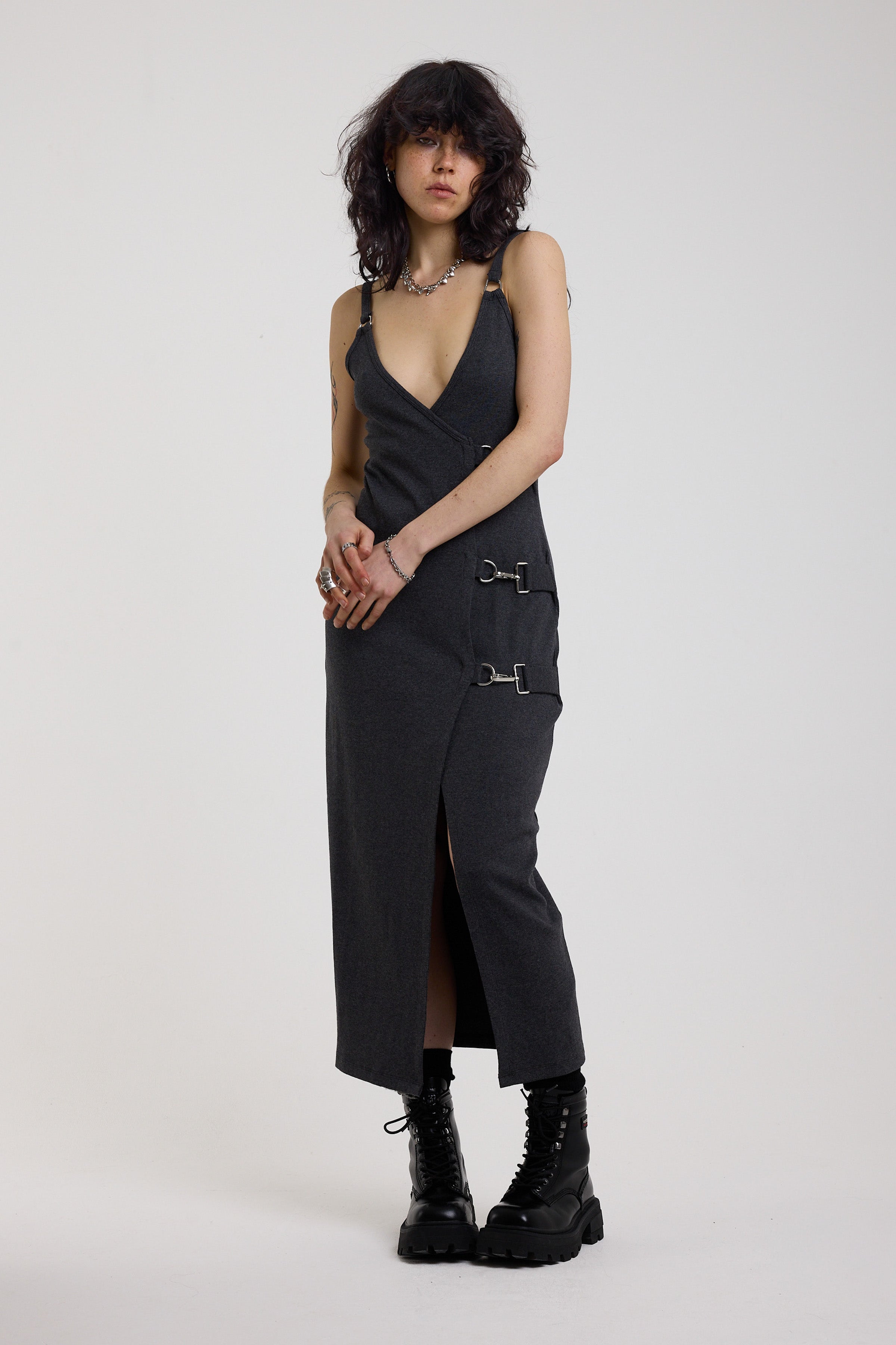 Charcoal plunging wrap dress with silver hardware clasps and D-ring strap detail, worn by model