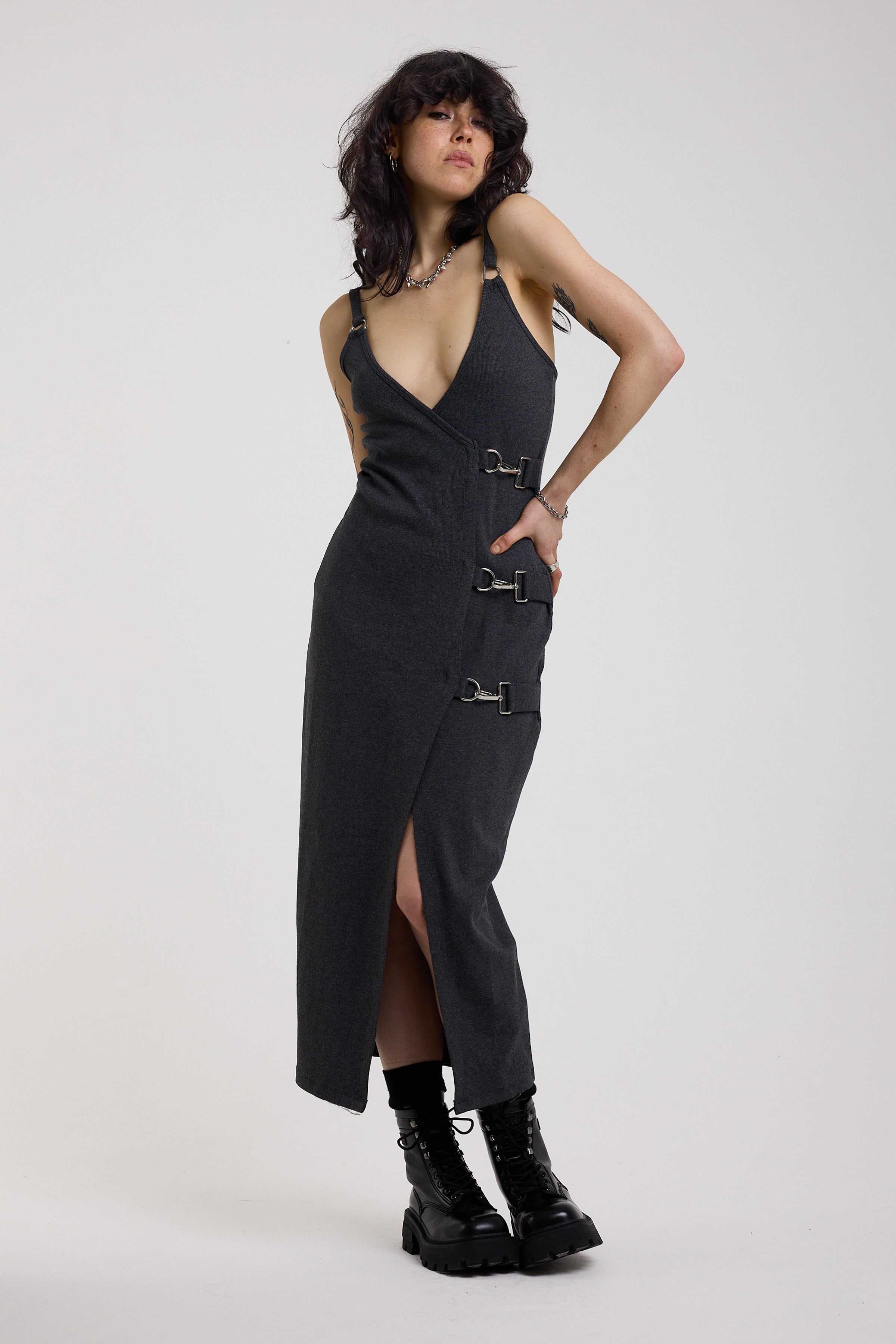 Charcoal plunging wrap dress with silver hardware clasps and D-ring strap detail, worn by model