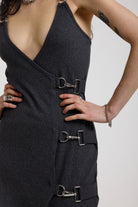 Close up of silver hardware buckles on charcoal plunging wrap dress, worn by model