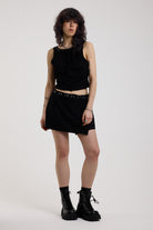 Black eyelet detail mini wrap skirt with adjustable ties, worn by model