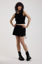 Black eyelet detail mini wrap skirt with adjustable ties, worn by model