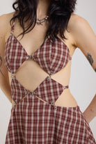 Grunge burgundy check strappy mini dress with cut out panels, silver hardware and tie back detail, worn by model