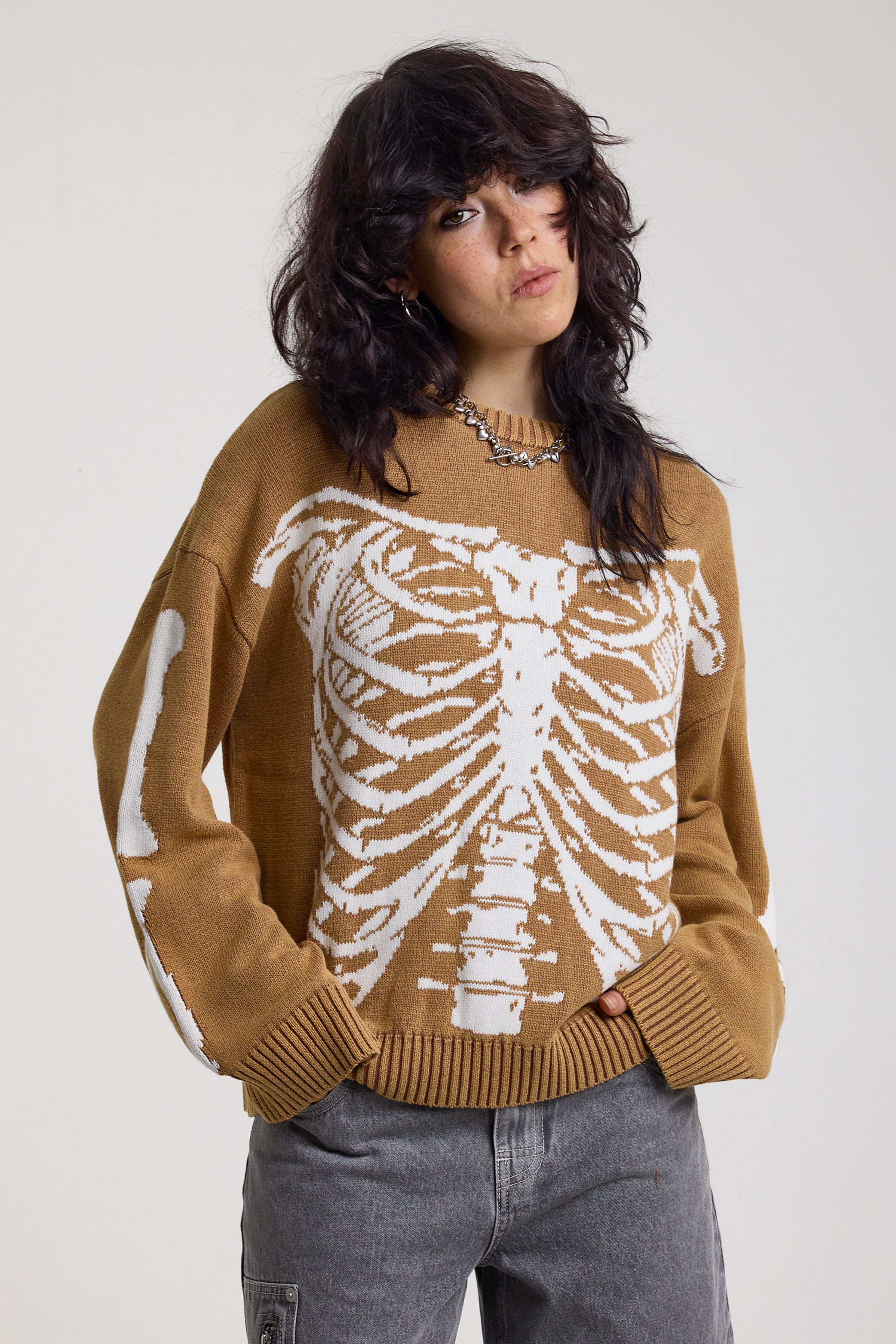 Brown oversized knit jumper with skeleton graphic, worn by model