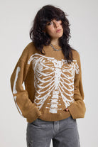 Brown oversized knit jumper with skeleton graphic, worn by model