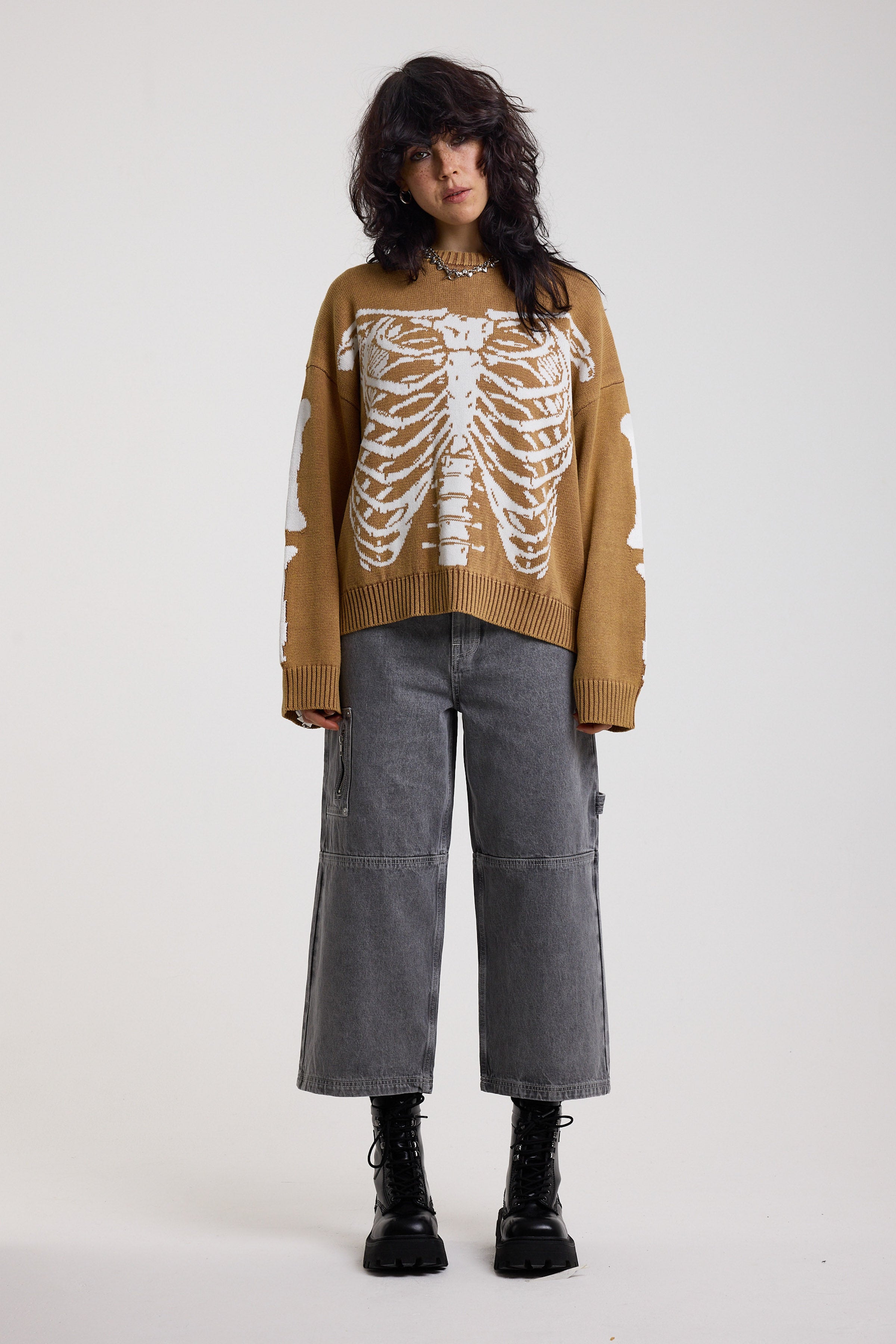 Brown oversized knit jumper with skeleton graphic, worn by model