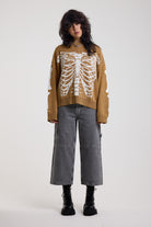 Brown oversized knit jumper with skeleton graphic, worn by model