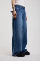 Dark blue ultra baggy wide leg jeans with hardware eyelet detail cinch back belt, worn by model