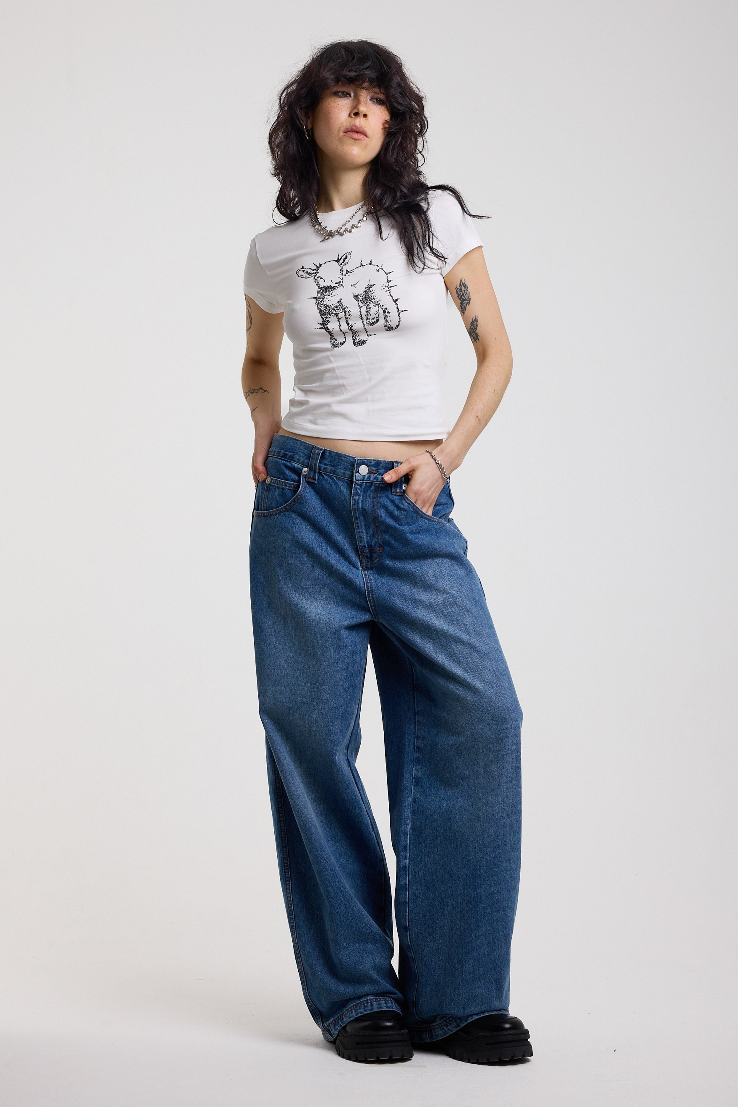 Dark blue ultra baggy wide leg jeans with hardware eyelet detail cinch back belt, worn by model