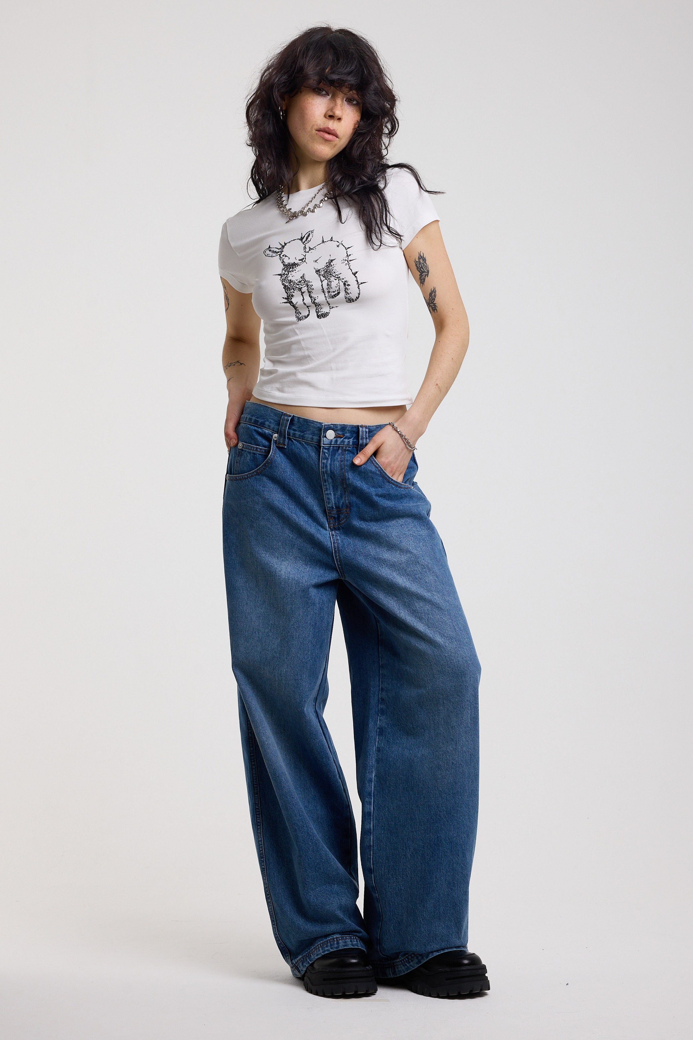 Dark blue ultra baggy wide leg jeans with hardware eyelet detail cinch back belt, worn by model