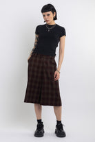 Burgundy check longline tailored shorts with silver D-ring hardware worn by model