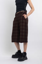 Burgundy check longline tailored shorts with silver D-ring hardware worn by model