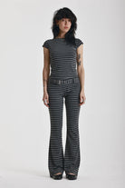 Grey and black stripe jersey flare trousers with eyelet belt, worn by model