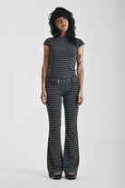 Grey and black stripe jersey flare trousers with eyelet belt, worn by model