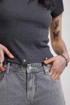 Close up of silver D-ring and stud detail on charcoal ribbed crop t-shirt, worn by model