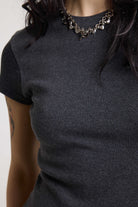 Close up of ribbed jersey fabric on charcoal ribbed crop t-shirt with silver D-ring hardware detail, worn by model