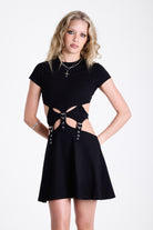Little black mini dress with cut outs and eyelet detail buckle straps, worn by model