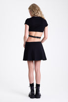 Little black mini dress with cut outs and eyelet detail buckle straps, worn by model