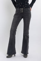 Washed black low rise flare jeans with no waistband and silver clasp hardware, worn by model