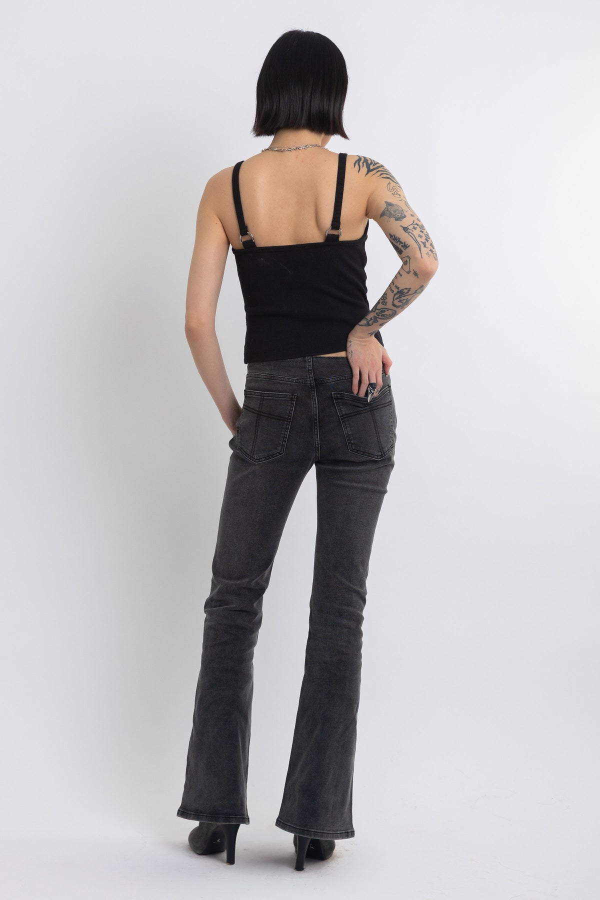 Black plunging wrap top with silver trigger clasps, worn by model