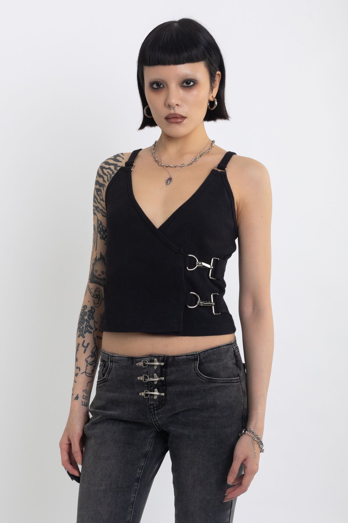 Black plunging wrap top with silver trigger clasps, worn by model