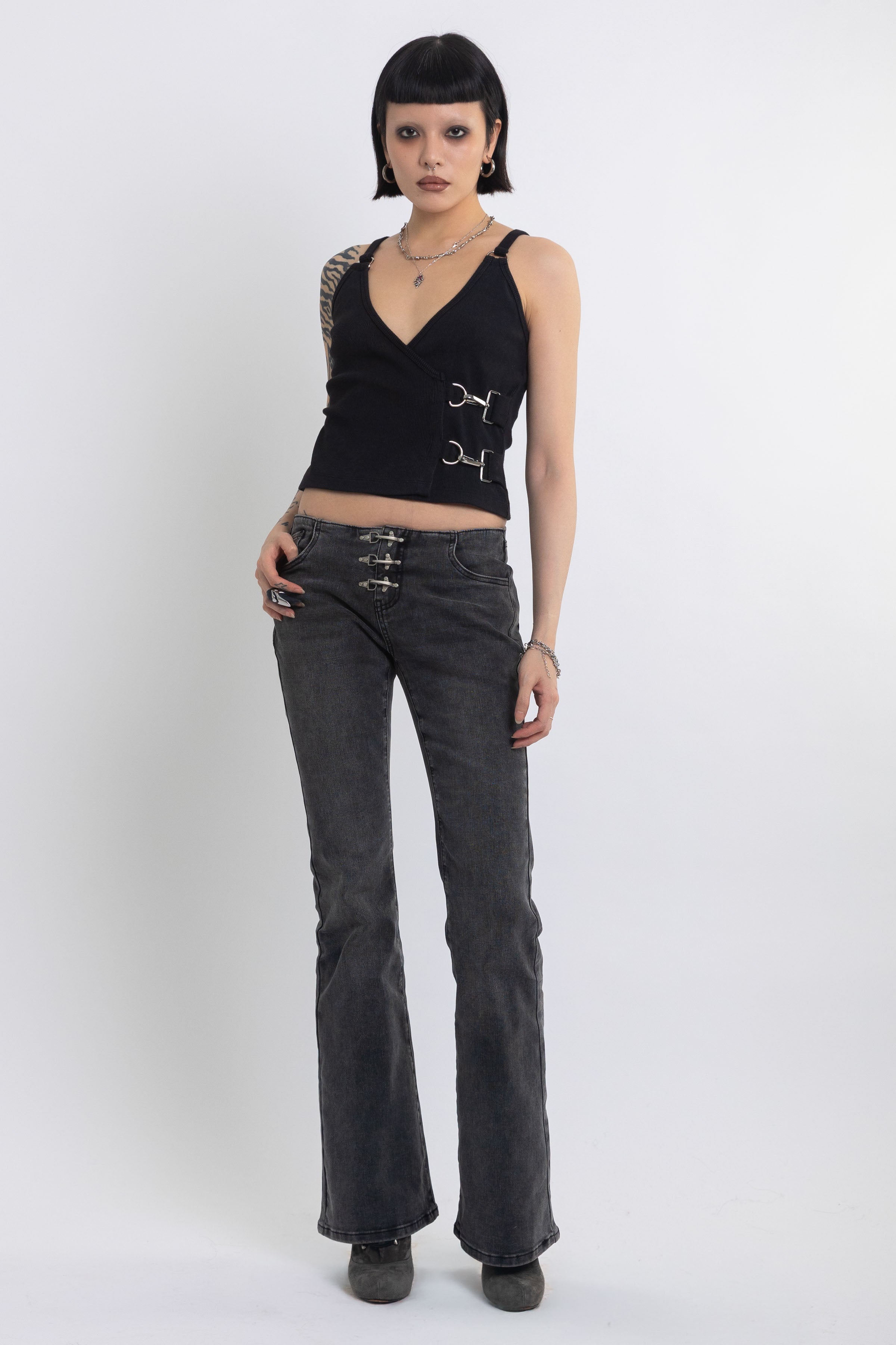 Black plunging wrap top with silver trigger clasps, worn by model
