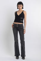 Black plunging wrap top with silver trigger clasps, worn by model