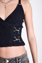 Black plunge wrap front top with silver trigger clasps and D-ring strap detail, worn by model