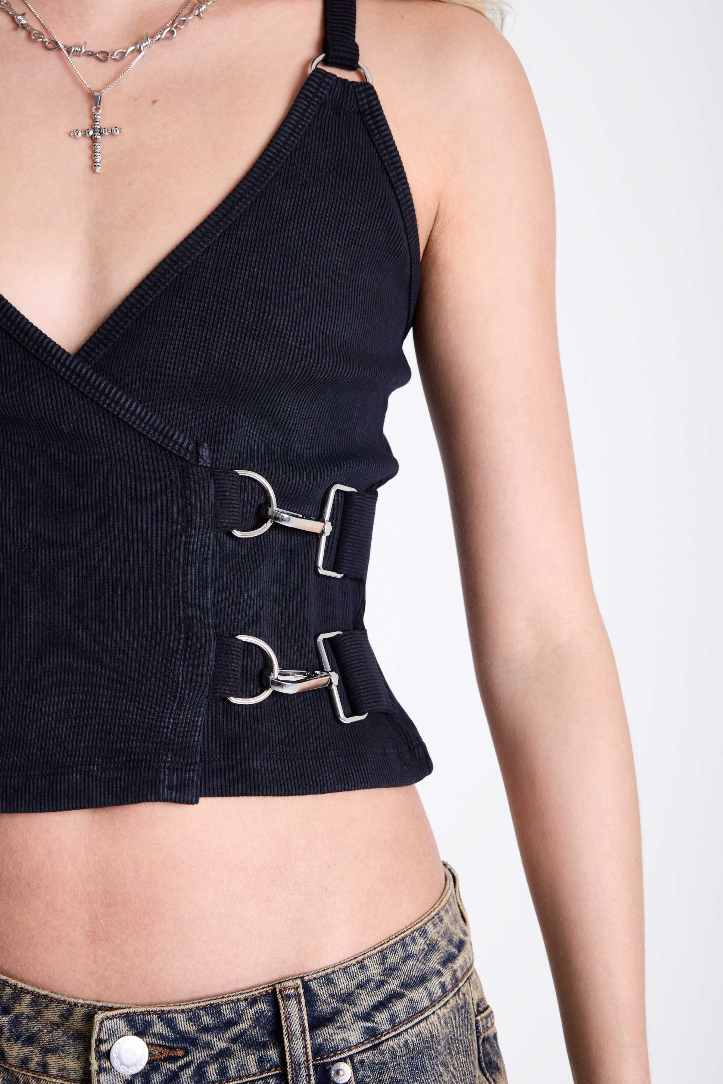 Black plunge wrap front top with silver trigger clasps and D-ring strap detail, worn by model