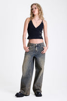 Black plunge wrap front top with silver trigger clasps and D-ring strap detail, worn by model