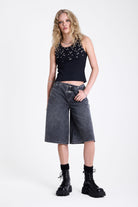 Washed black longline oversized denim jorts with no waistband and silver latch clasp detail, worn by model