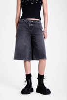 Washed black longline oversized denim jorts with no waistband and silver latch clasp detail, worn by model